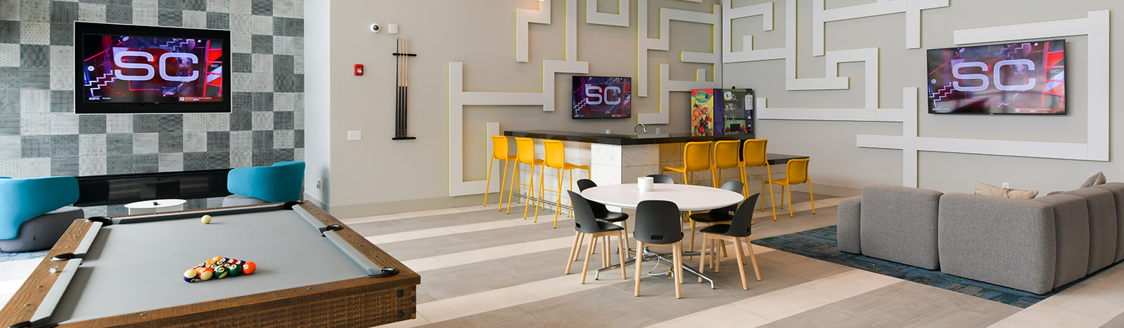 Lounge room with pool table, TV screens, and seating.