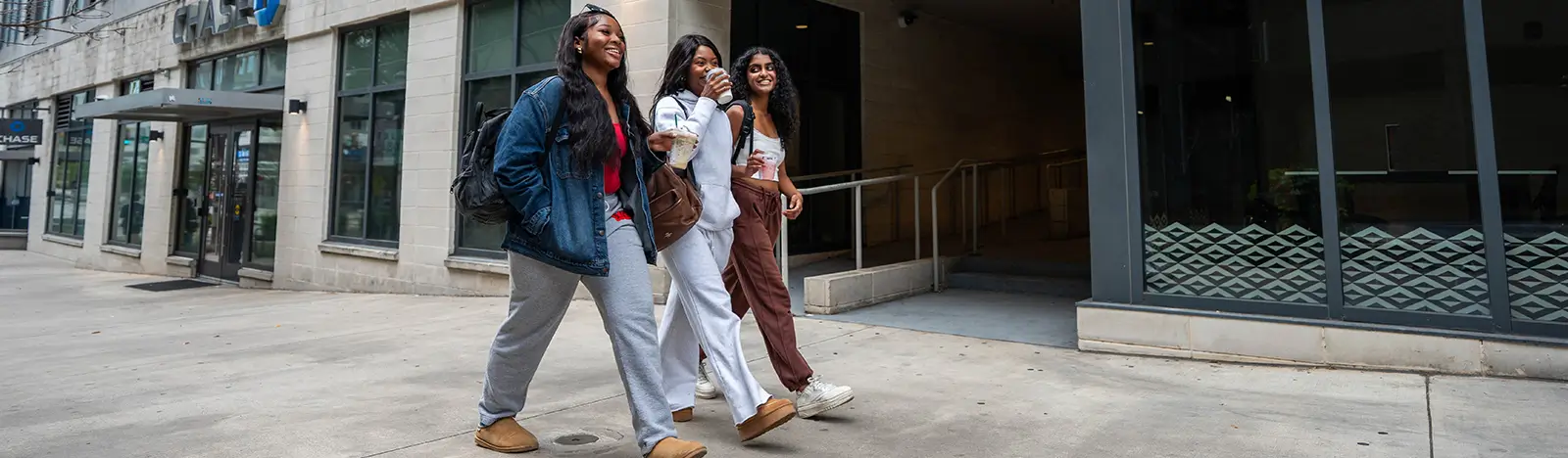 Three young adults walking on a city sidewalk
